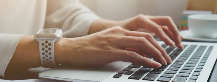 Dłonie piszące na laptopie