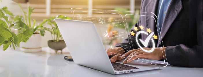 Osoba pracująca na laptopie z grafiką przedstawiającą ocenę pięciu gwiazdek i znak zatwierdzenia