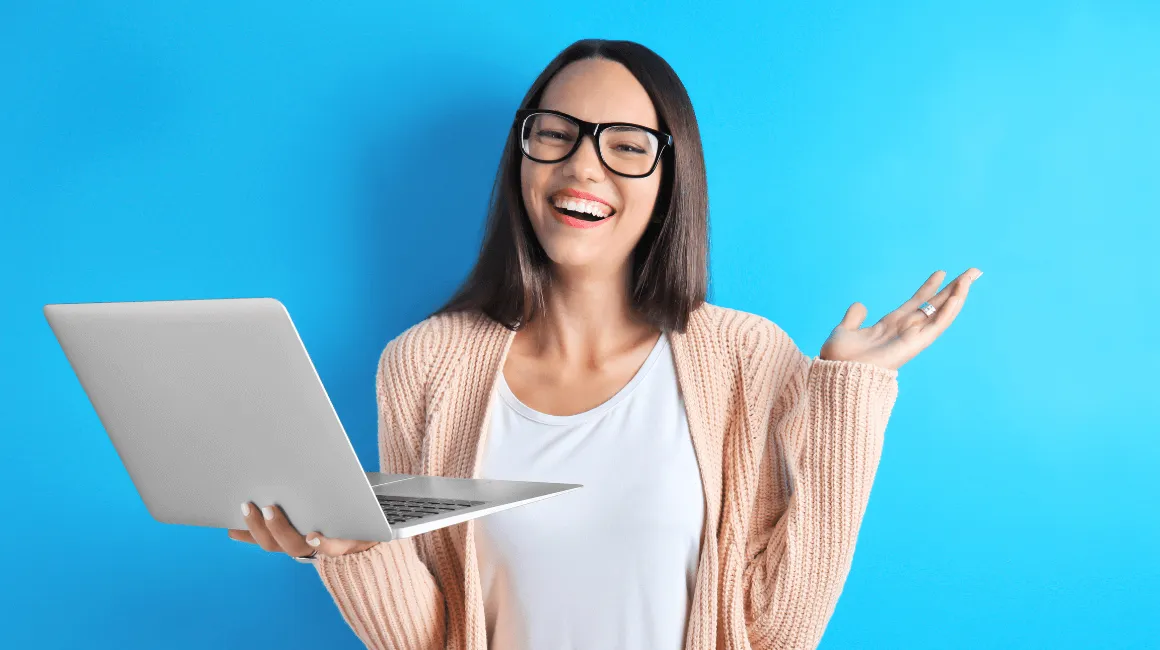 Uśmiechnięta kobieta z laptopem w dłoniach na niebieskim tle